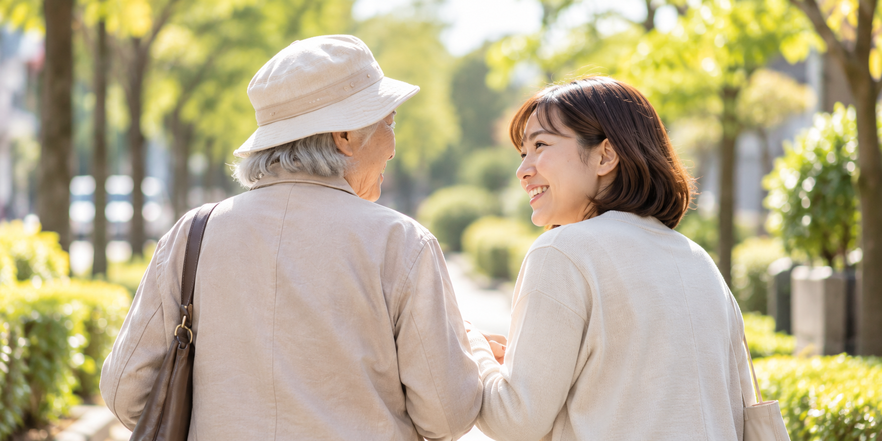 緑道を歩きながら会話する高齢女性と家族